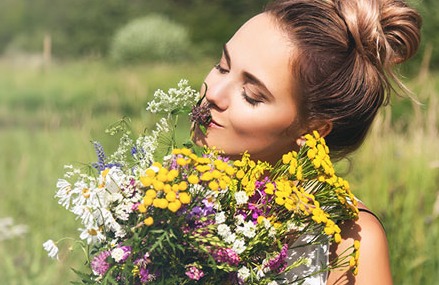 Frau mit Wiesenblumenstrauß